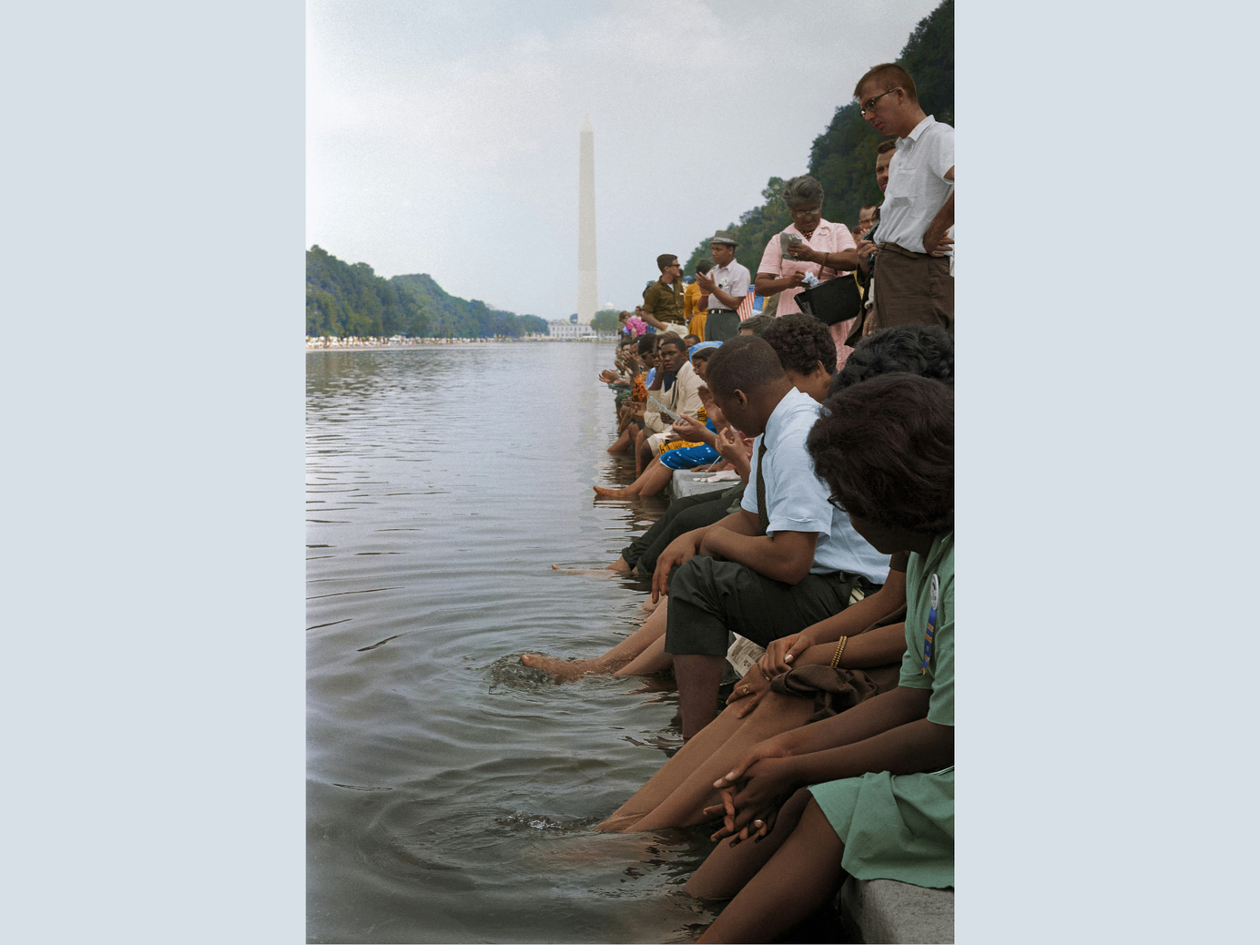 Photograph taken at the March on Washington. Black protesters putting their feet in the reflecting pool. Colorized.