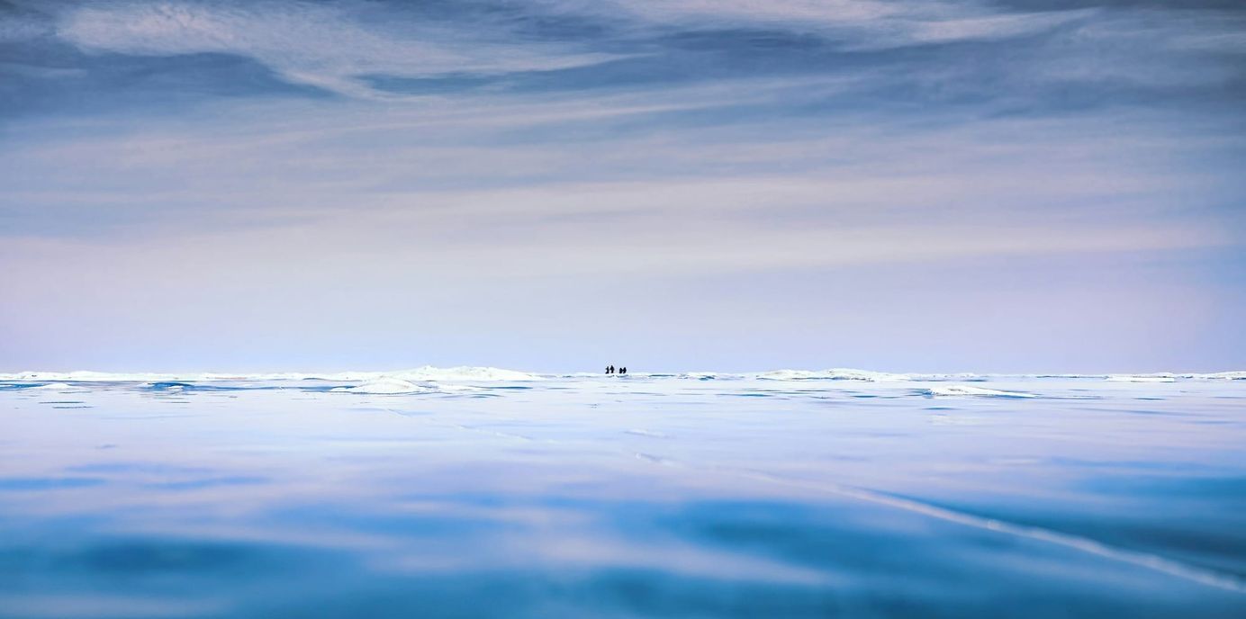 photo of a glacier with the sky reflecting
