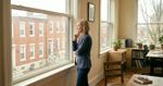 A leader paused in stillness before a window in reflection the moment before a meeting begins