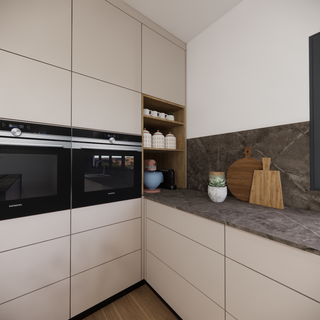 Modern kitchen corner with built-in ovens, open shelves, and marble countertop with kitchen accessories.