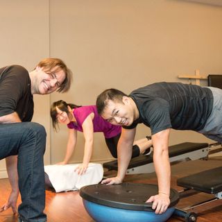 Men and women in Vancouver doing strength training with a personal trainer inside Tsquared Personal Training studio at the Sandman Hotel.