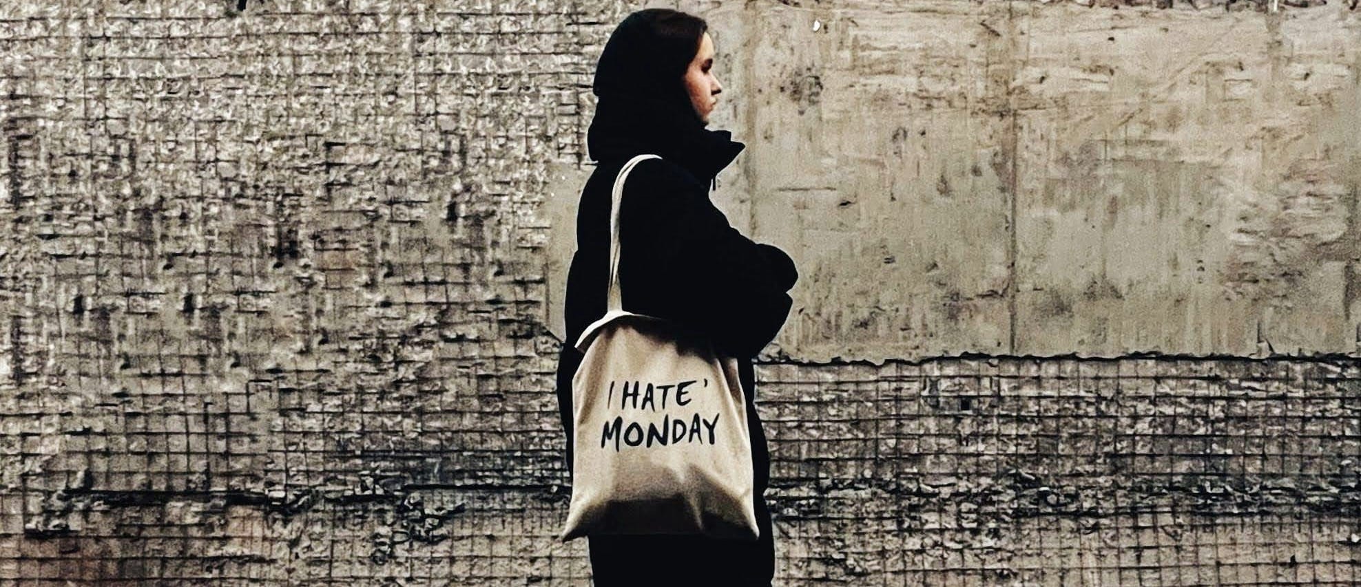 a woman standing on a street holding a bag