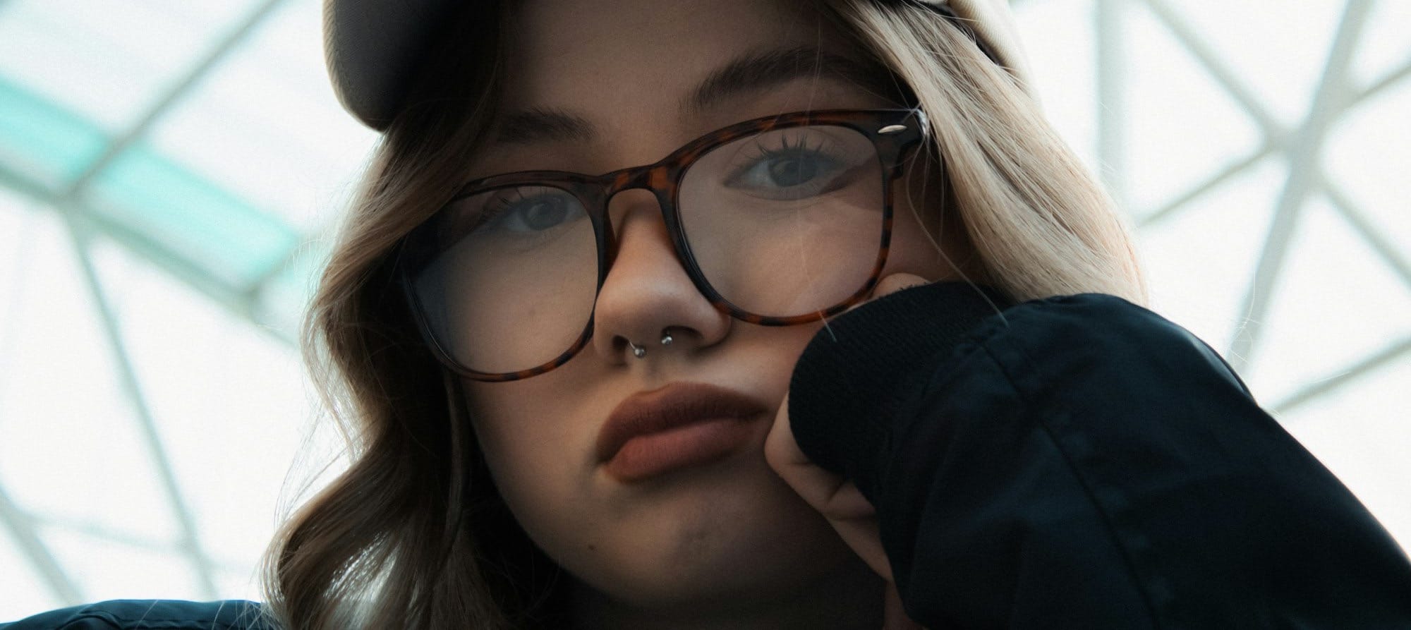 Young woman wearing glasses and a hat.