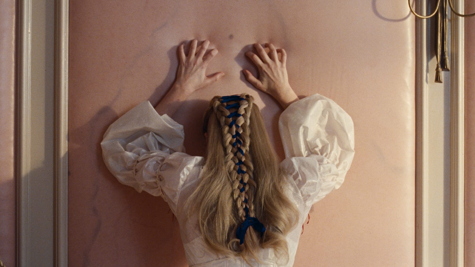 Catherine Earnshaw (Margot Robbie) claws at a wall made to look like flesh in Wuthering Heights.