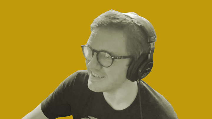 AP Thomson wears headphones and looks to the left of the camera while on the grokludo podcast.