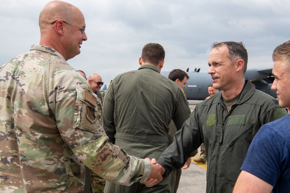 Colonel Powell shaking hands with his commander on the flight line after his final flight as Operations Group Commander.