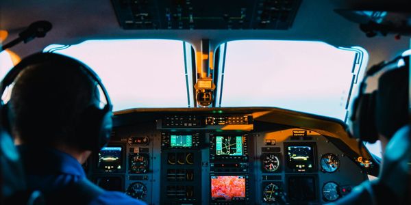 Two pilots watch on in airline cockpit while the autopilot flies.