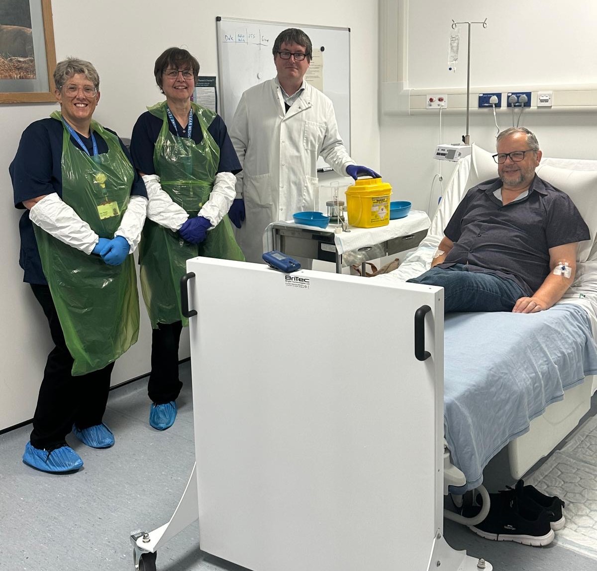 A doctor and two nurses standing next to a patient's bed