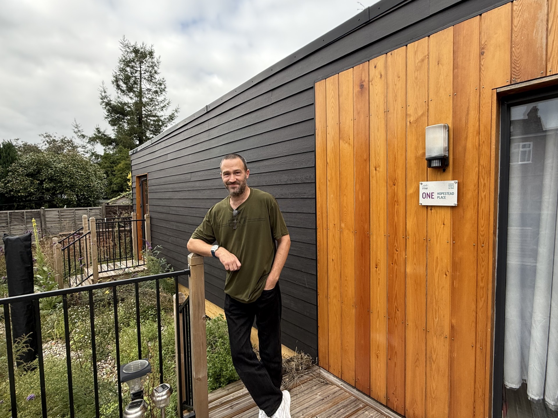 Hopestead Place resident Lewis Paterson in front of the ‘pod’ where he currently lives