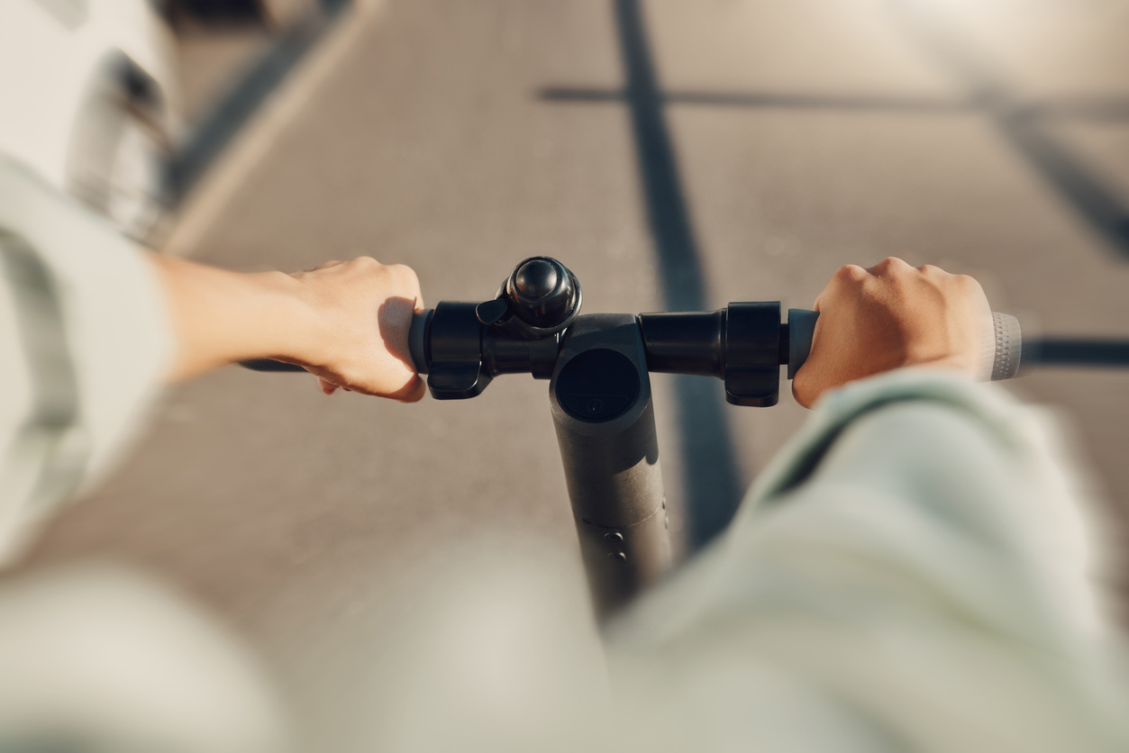 A man riding an e-scooter on a road