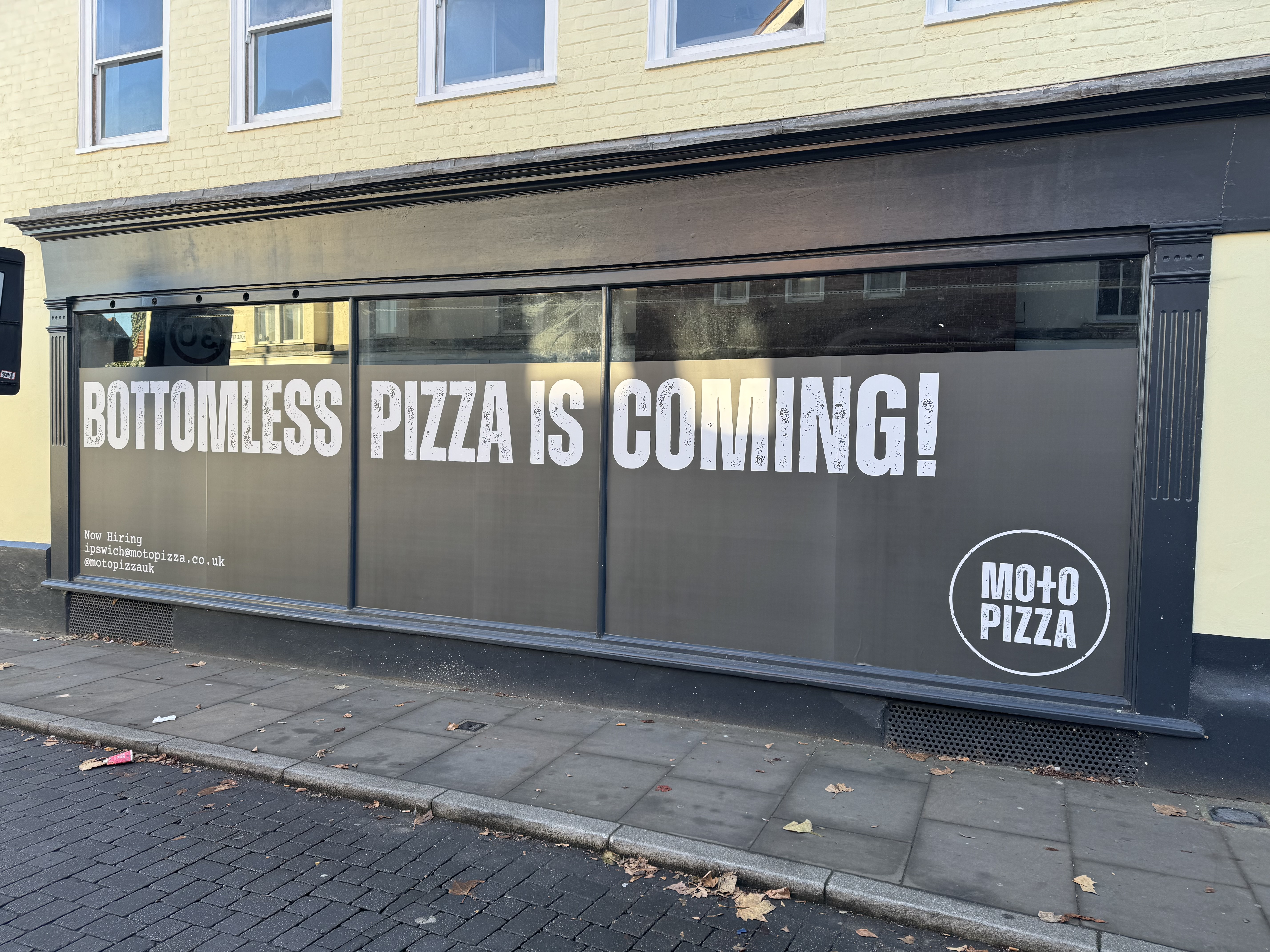 Bottomless pizza is coming sign in window of premises on Fore Street, Ipswich