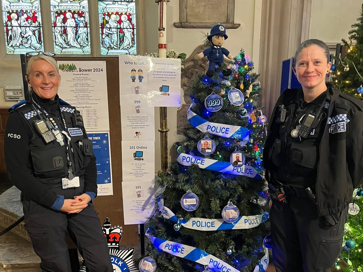 Two police officers show off their Christmas tree