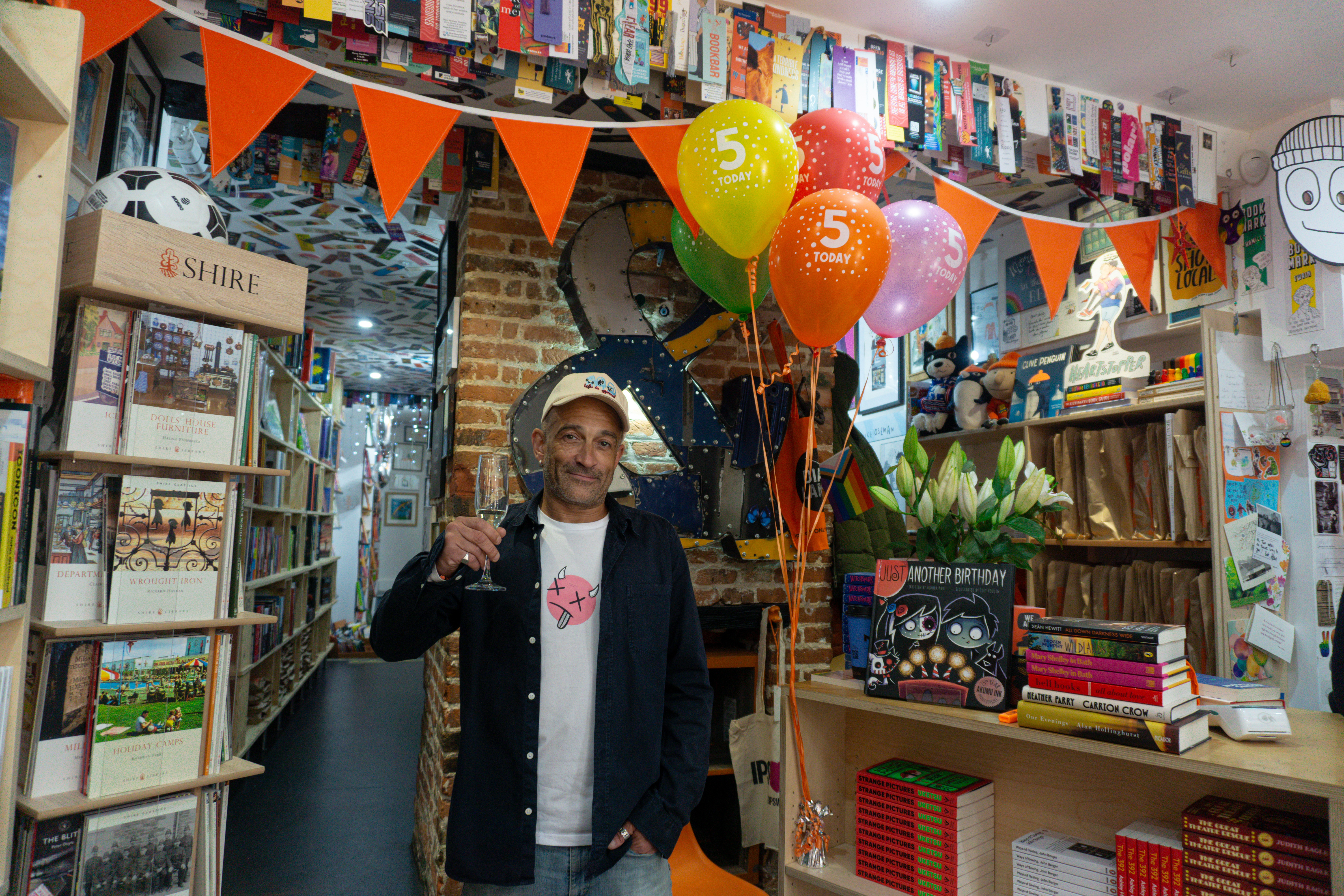 Book shop owner holding a glass celebrating 5 years of business