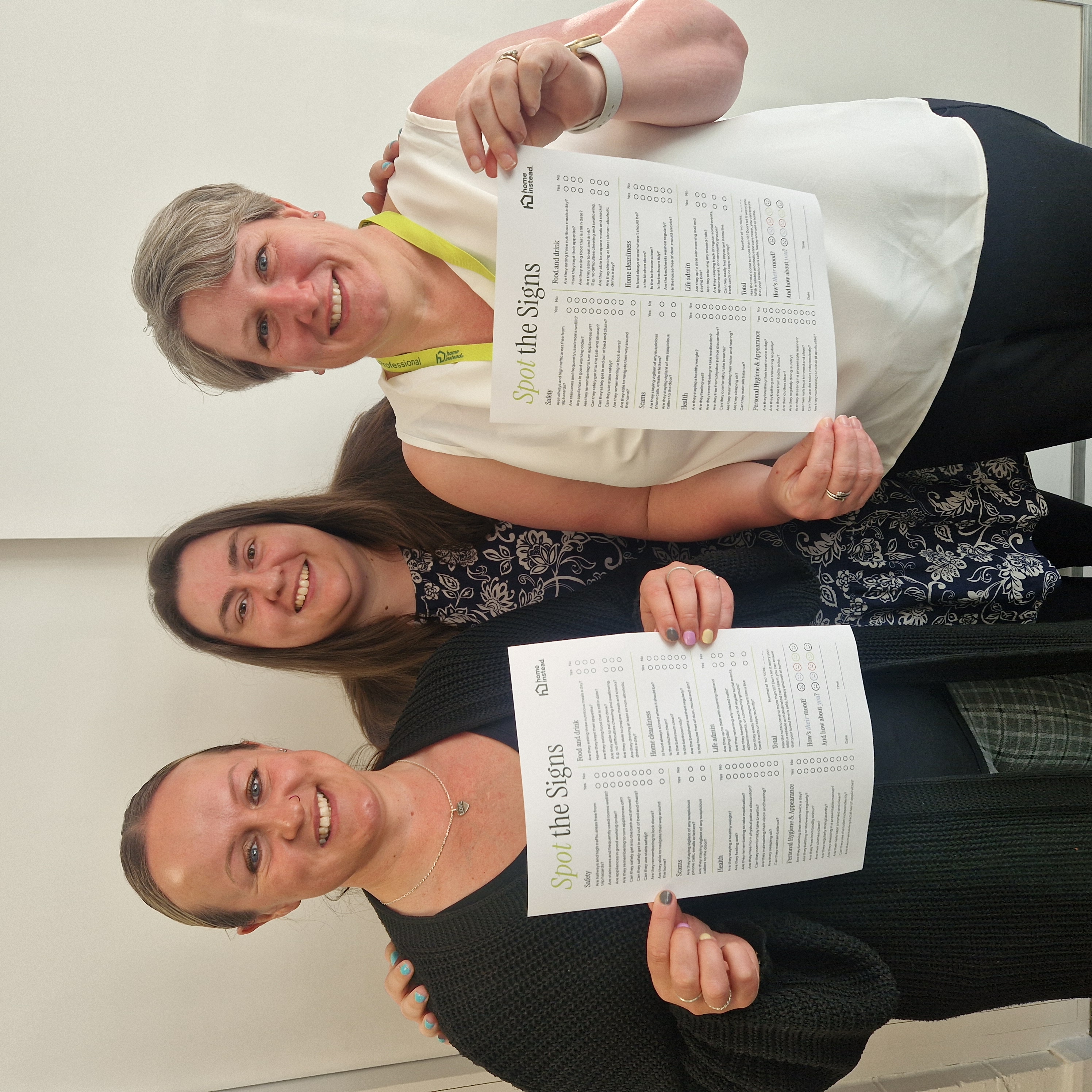 The Home Instead Ipswich, Felixstowe & Woodbridge team holding the Spot the Signs checklist