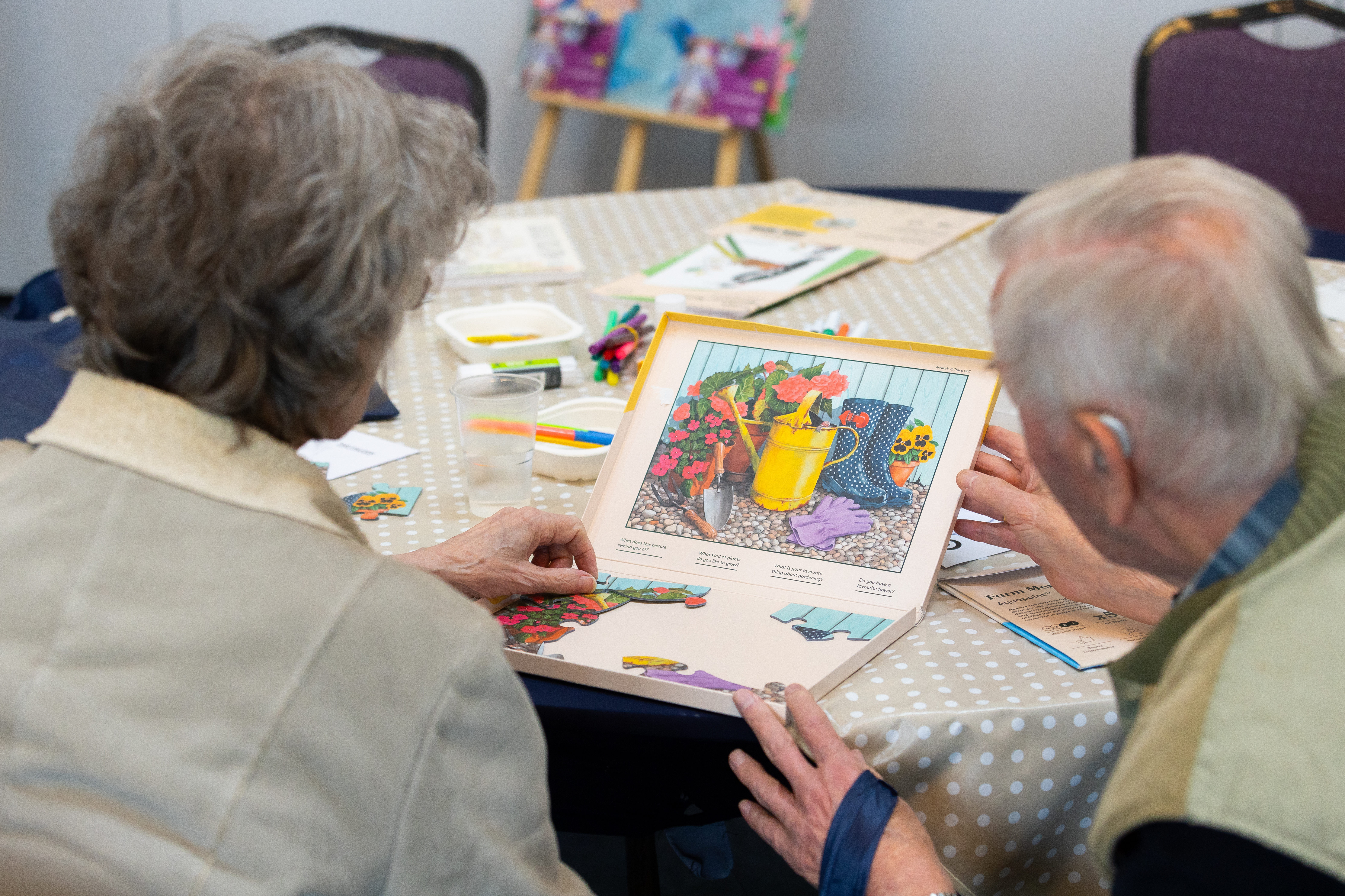 An elderly couple doing a puzzle together