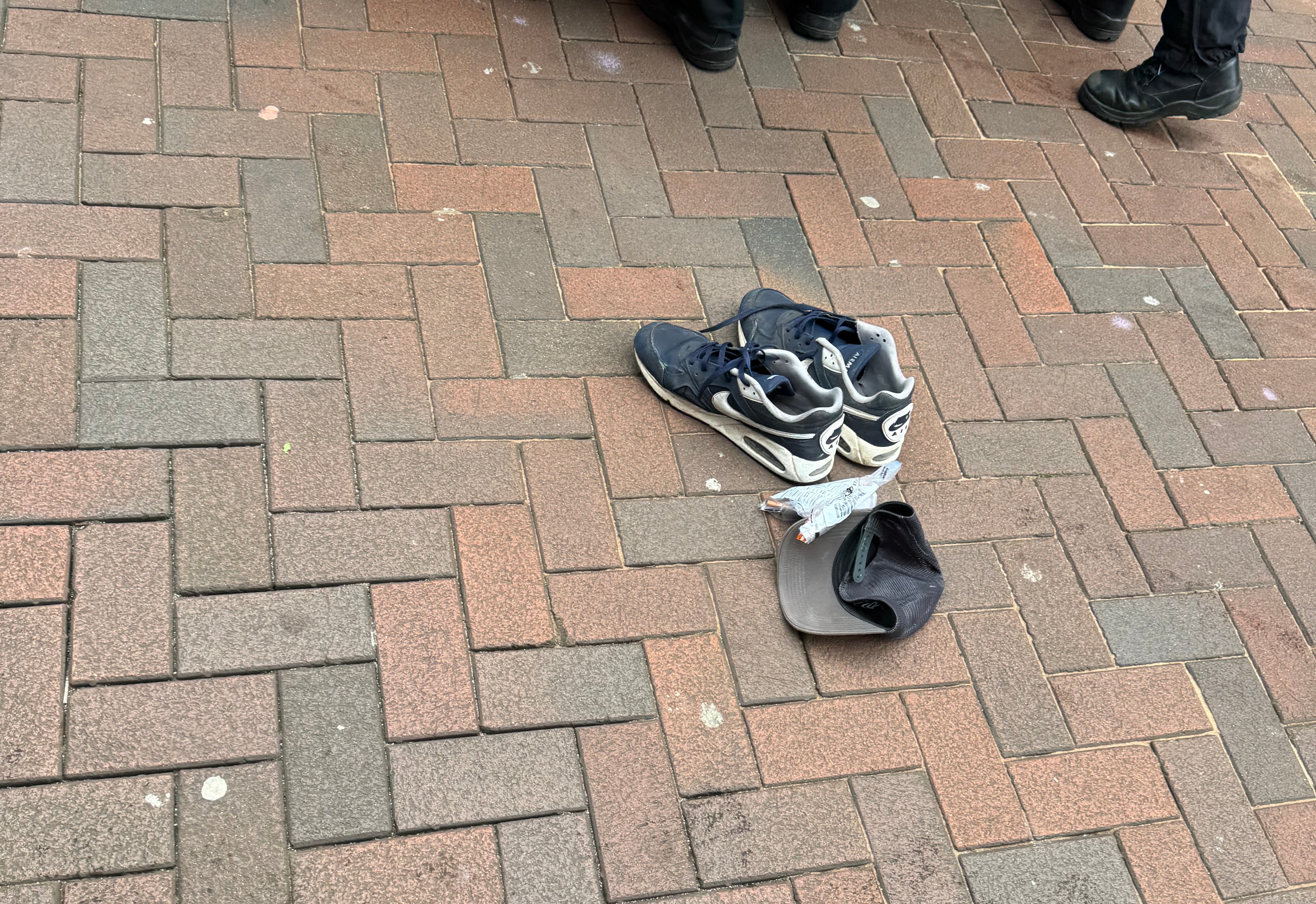 A police evidence bag and items of clothing were seen next to a police van