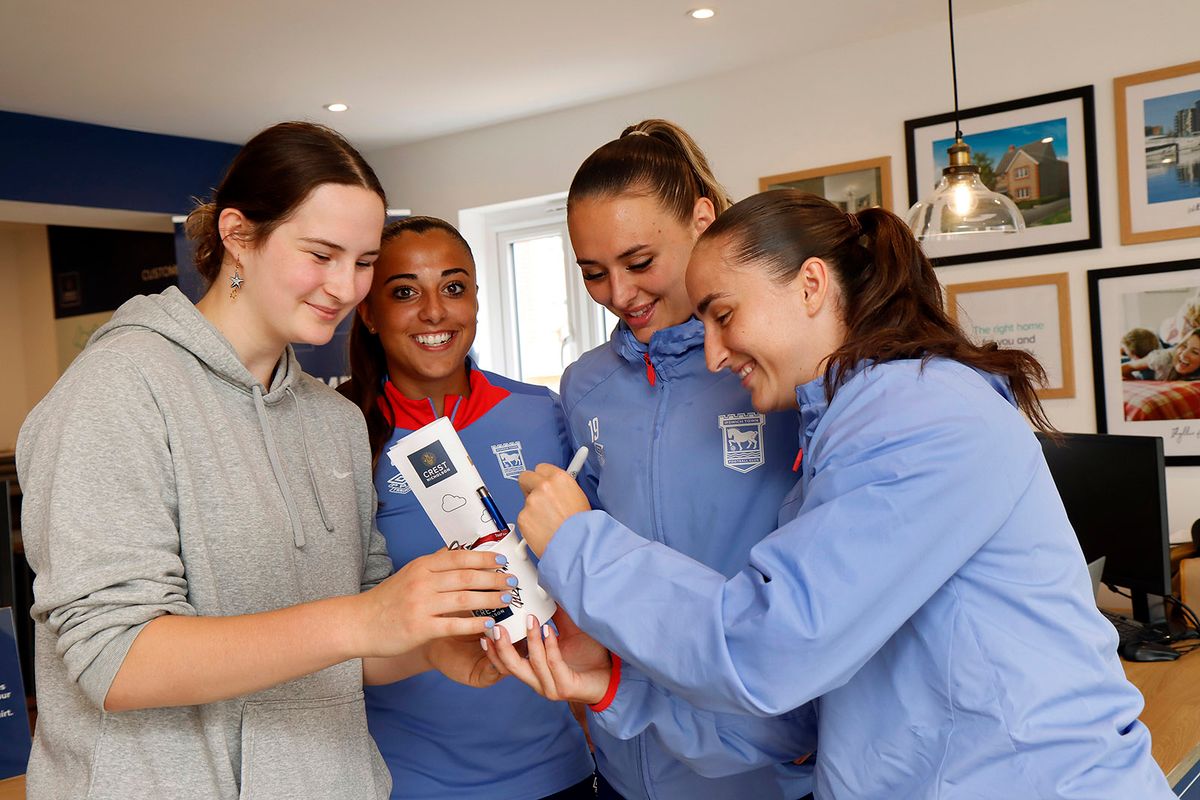 Ipswich Town Ladies FC players with a fan in a bedroom