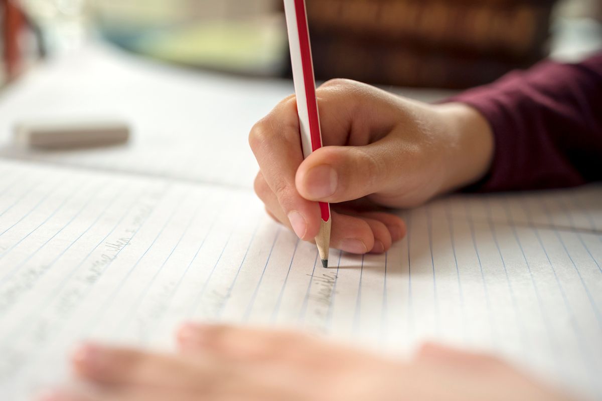 A pupil writing in a school book