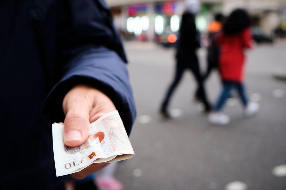 Man holding two £10 notes