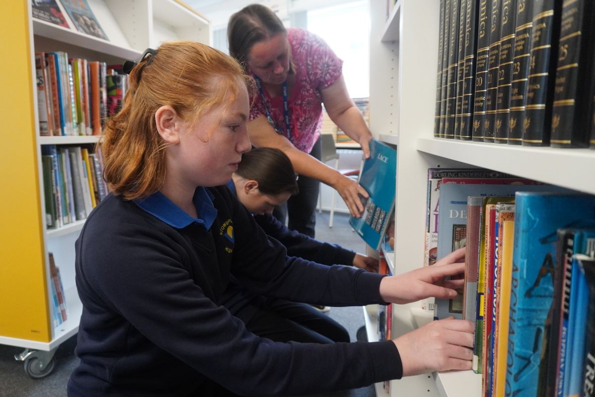 Stowupland High School’s library technicians grab a book to read in the school’s new library space