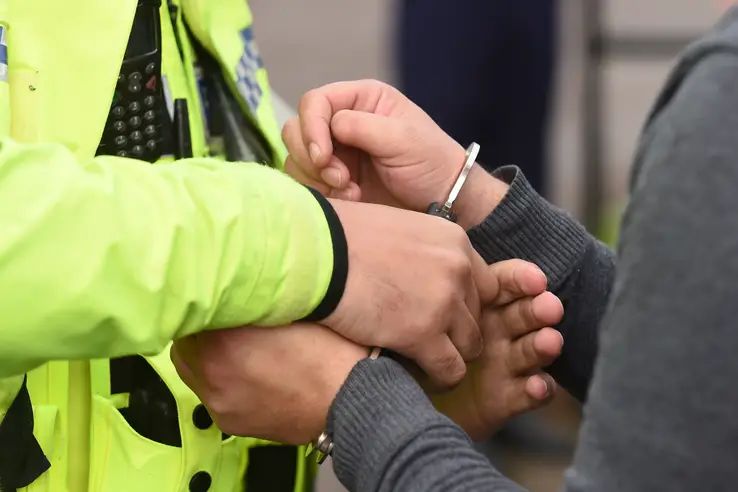 Young male being arrested by police