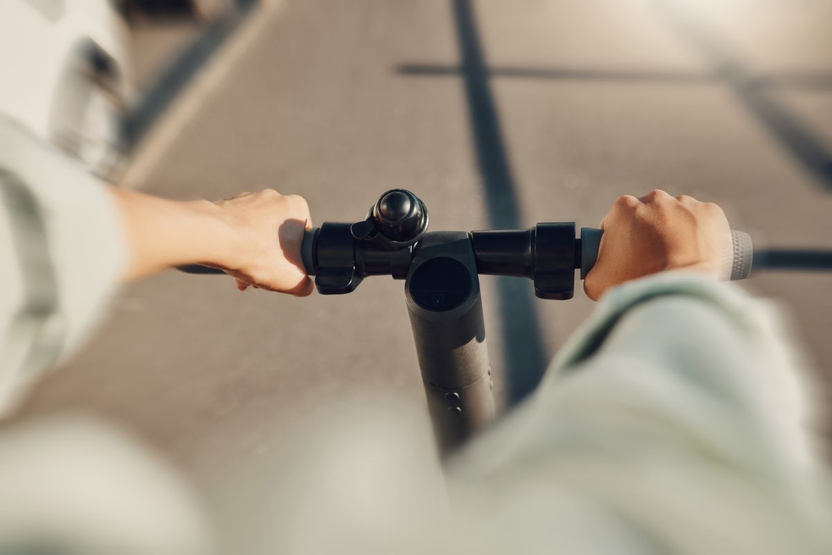 A man riding an e-scooter on a road