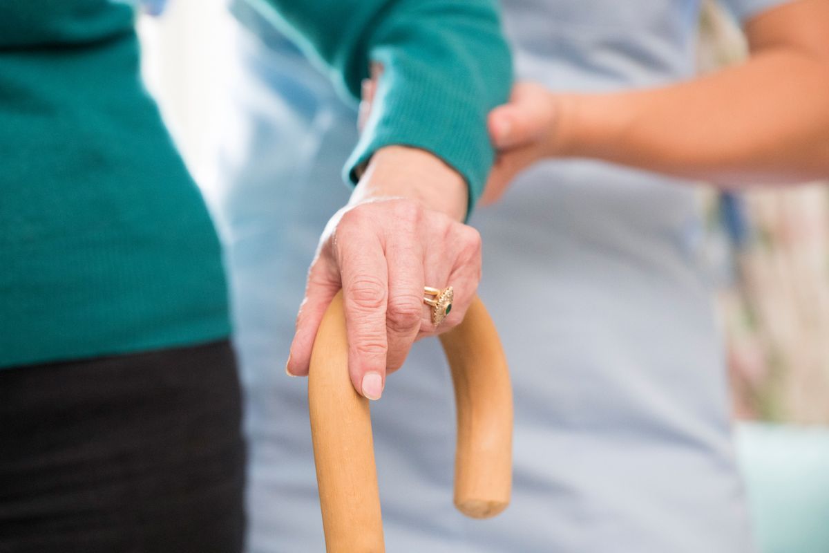 An elderly lady being assisted by an adult social care worker