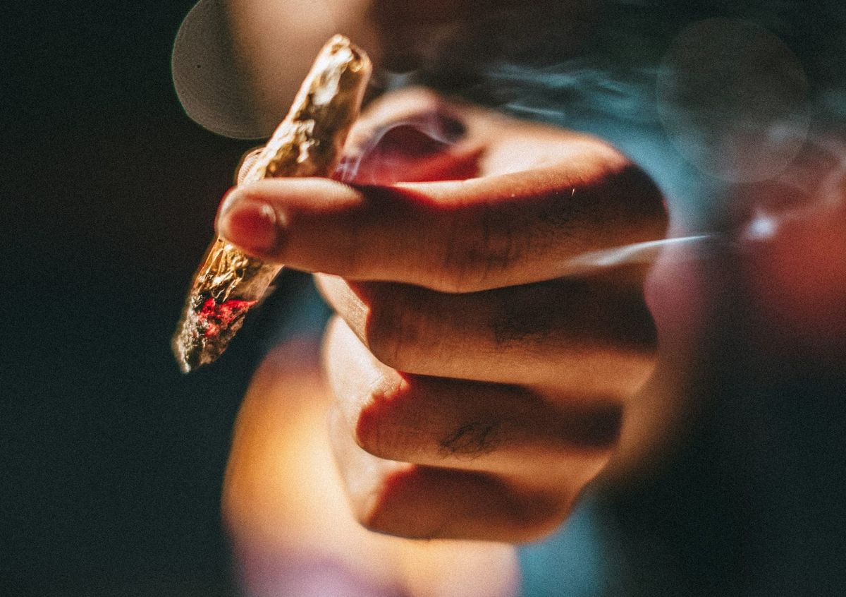 Young person holding a joint 