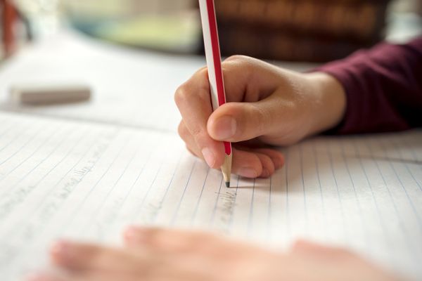 A pupil writing in a school book