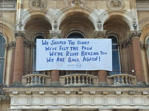 A banner on the Corn Exchange reads "We share the glory, we've felt the pain, we're right behind you, we are back again"