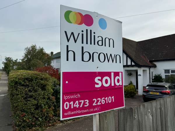 A sold sign in front of a bungalow