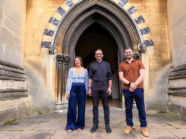 Be Peters, Tom Mumford and Jordan Bambridge in front of a church