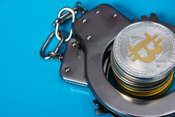 Handcuffs with a bitcoin stack