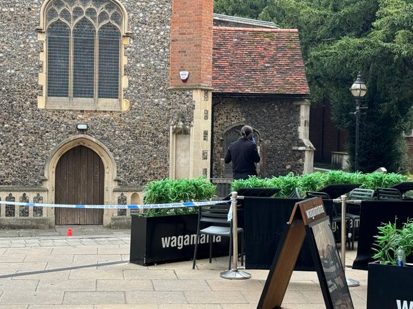 A police cordon with a policewoman on the phone at the scene