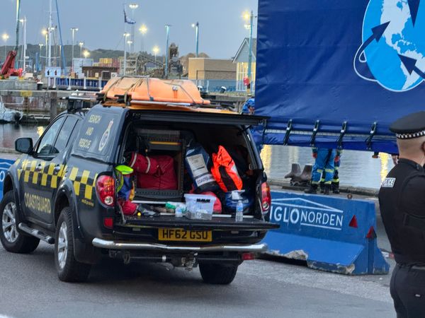 Rescue teams can be seen operating along the water edge