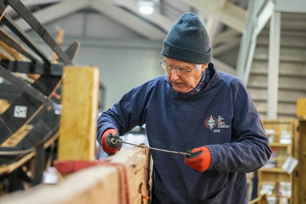 A volunteer working on a life-size replica of a Viking ship