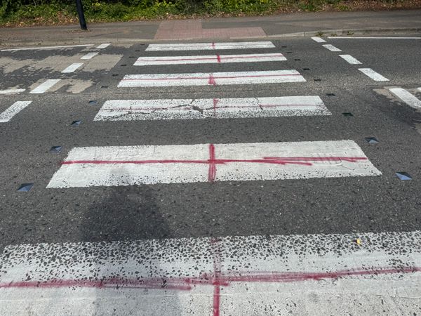 A pedestrian crossing on Shepherd's Drive in Pinewood painted with St George's Crosses