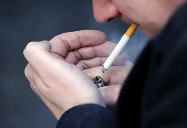 A man lighting a cigarette