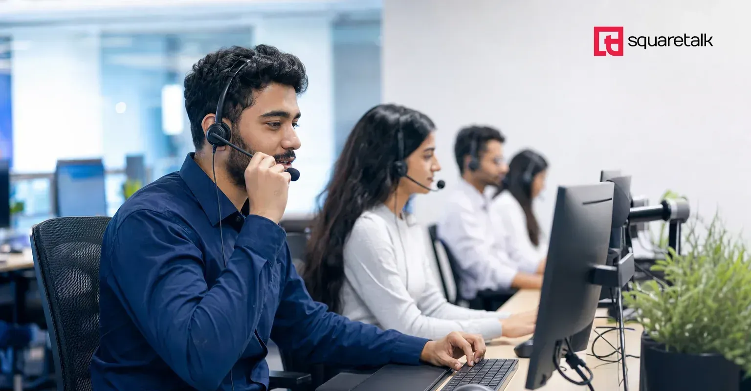 Diverse BPO contact-center team in headsets handling outbound calls at their workstations