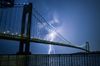 The Verrazzano Bridge at night, a bolt of lightning behind it