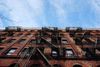 A view of a NYC fire escape with AC units next to it.