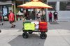 A vendor cart with a sign that says "We are workers" at Corona Plaza.