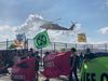 Protesters' banners flap in the prop-wash of a helicopter.