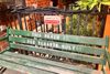 A sign that reads "Sorry but the bench is private" above a green bench with "this bench is for tenants only" spraypainted on