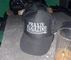 A trucker hat that says "Praxis Magazine"