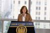 Governor Kathy Hochul at a rally celebrating congestion pricing at a podium that reads "Cleaner air. Better transit. Less tra