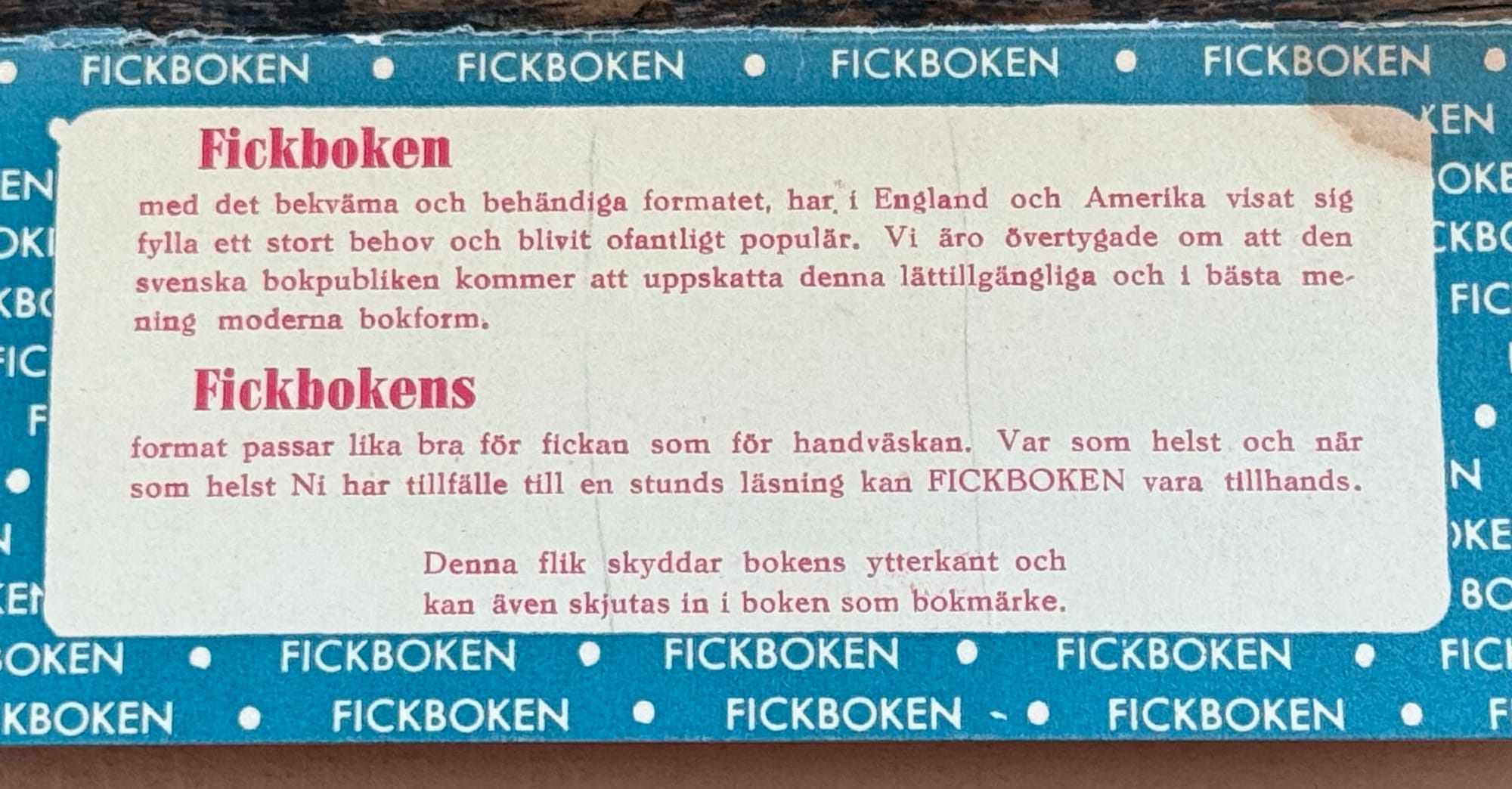 Bild på läsfliken. Texten på fliken lyder: Fickboken med det bekväma och behändiga formatet, har i England och Amerika visat sig fylla ett stort behov och blivit ofantligt populär. Vi äro övertygade om att den svenska bokpubliken kommer att uppskatta denna lättillgängliga och i bästa mening moderna bokform. Fickbokens format passar lika bra för fickan som för handväskan. Var som helst och năr som helst Ni har tillfälle till en stunds läsning kan FICKBOKEN vara tillhands. Denna flik skyddar bokens ytterkant och kan även skjutas in i boken som bokmärke.