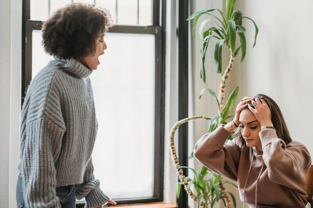 A woman overwhelmed while being blamed by another person — the hidden emotional cost of living in a blame cycle.