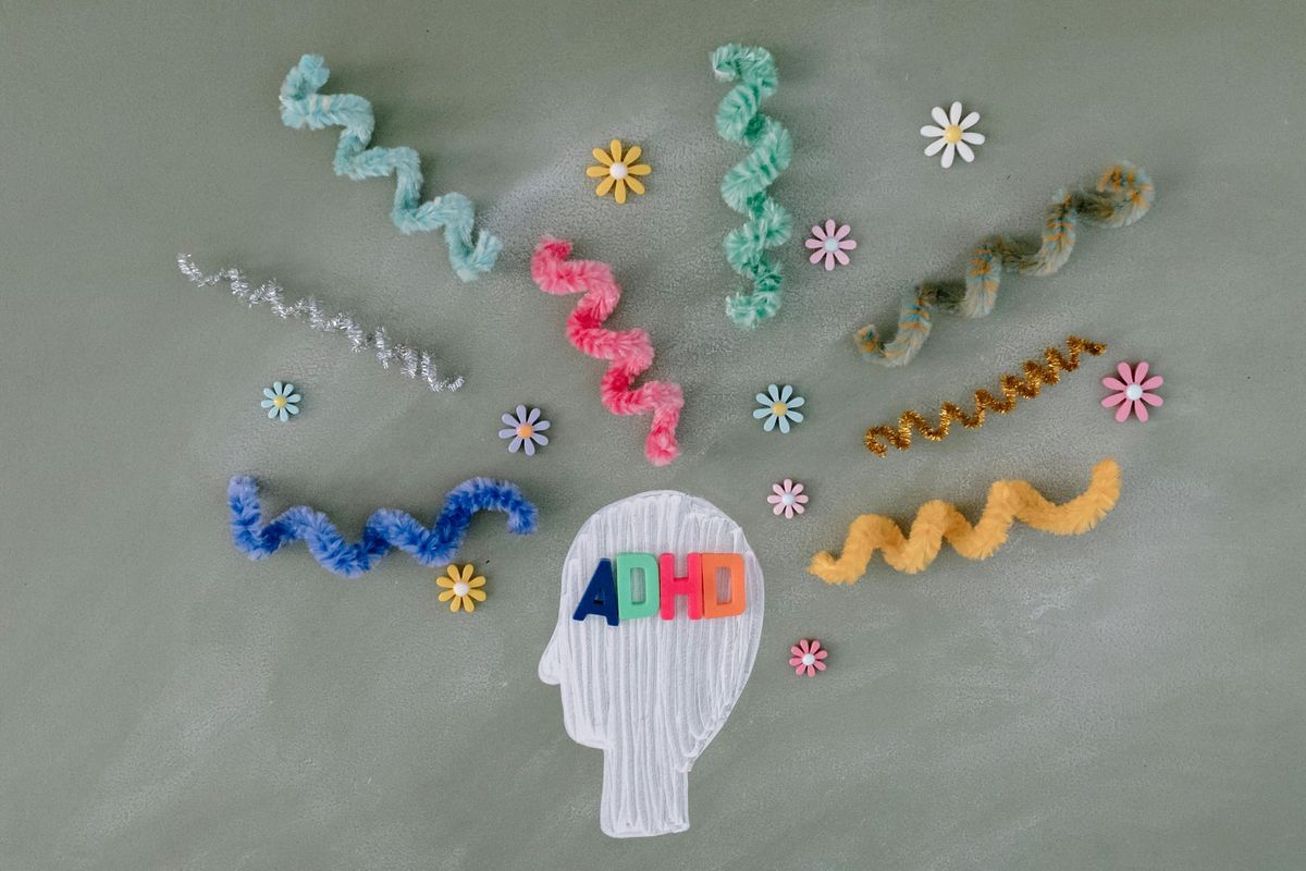 Paper head with colorful neural pathways radiating outward, representing nervous system regulation and its role in manifestation and healing