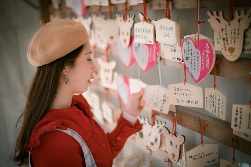 女孩在神社閱讀繪馬願望，象徵睡前顯化與潛意識意圖設定的力量